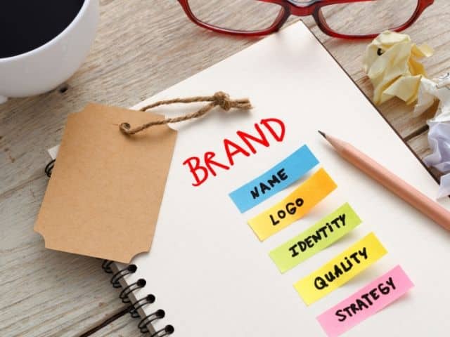 brand recognition on white notebook. Keep reading to learn how to convert social media into sales.