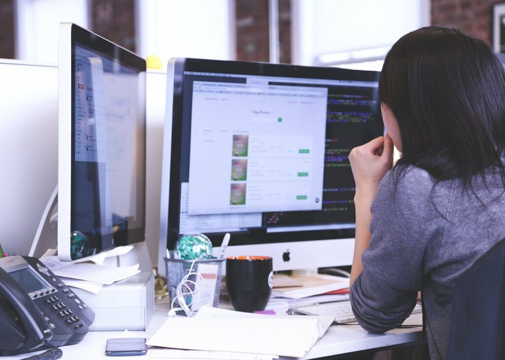 Woman using multiple monitors