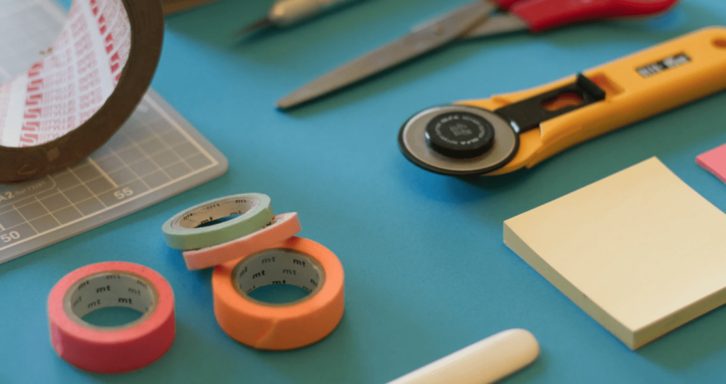 Colorful tools on a teal table. Keep reading to get the best blogging tools for beginners, bloggers and content creators.
