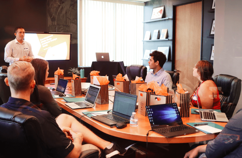 21 Ways to Repurpose Content with team sitting around the table discussing next marketing strategy.
