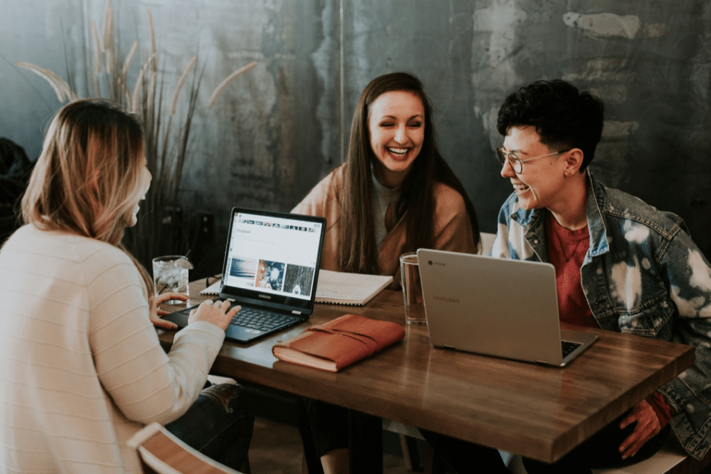 Bloggers sitting at the table blogging. When conducting research online the keyword is very important so keep reading to learn about AI Keyword Research.