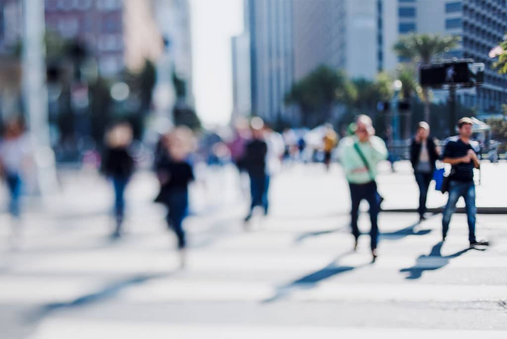 Business people walking through downtown buildings for work. Keep reading to learn easy local seo marketing for your blog.