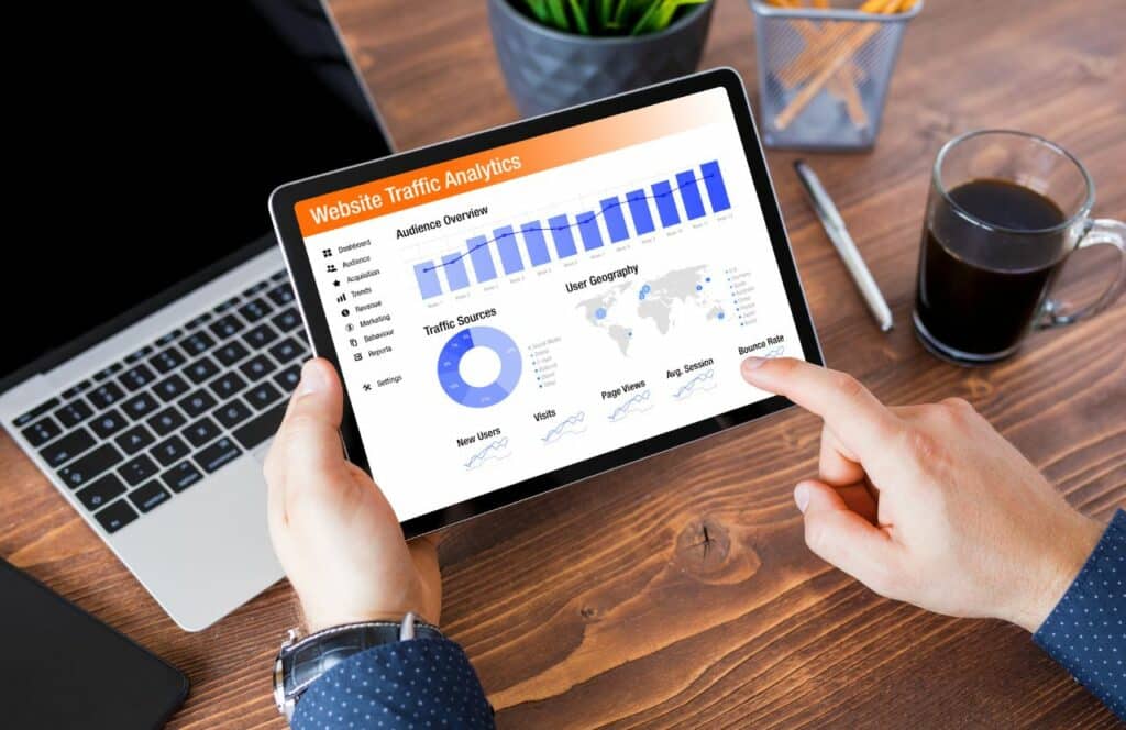 A man looking at website traffic analytics on his i-pad to better understand blog audience. "What's the point of blogging?" click here to read more.