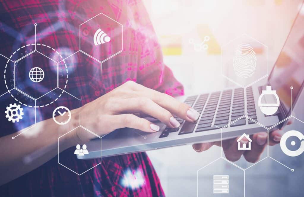 A woman in a pink plaid shirt typing on a laptop as she analyzes data for key performance indicators. "What's the point of blogging?" click here to read more.