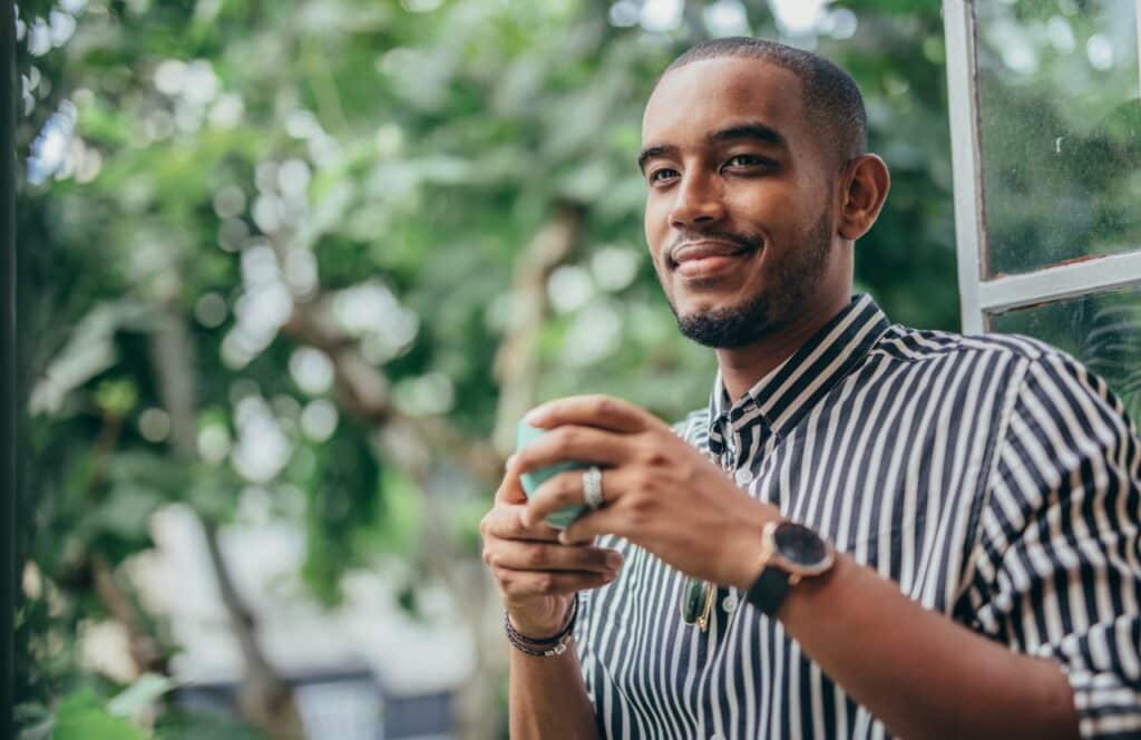 Black man taking a five minute break to walk outside in nature. Keep reading for tips on how to write blog posts faster.