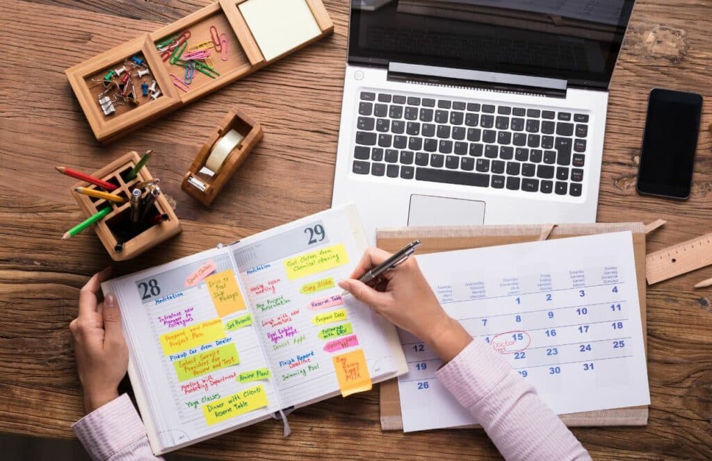 Desk with calendar and weekly planner with time slots blocked off for writing. Keep reading to learn the answer to the question, "Is Blogging Still Relevant?"