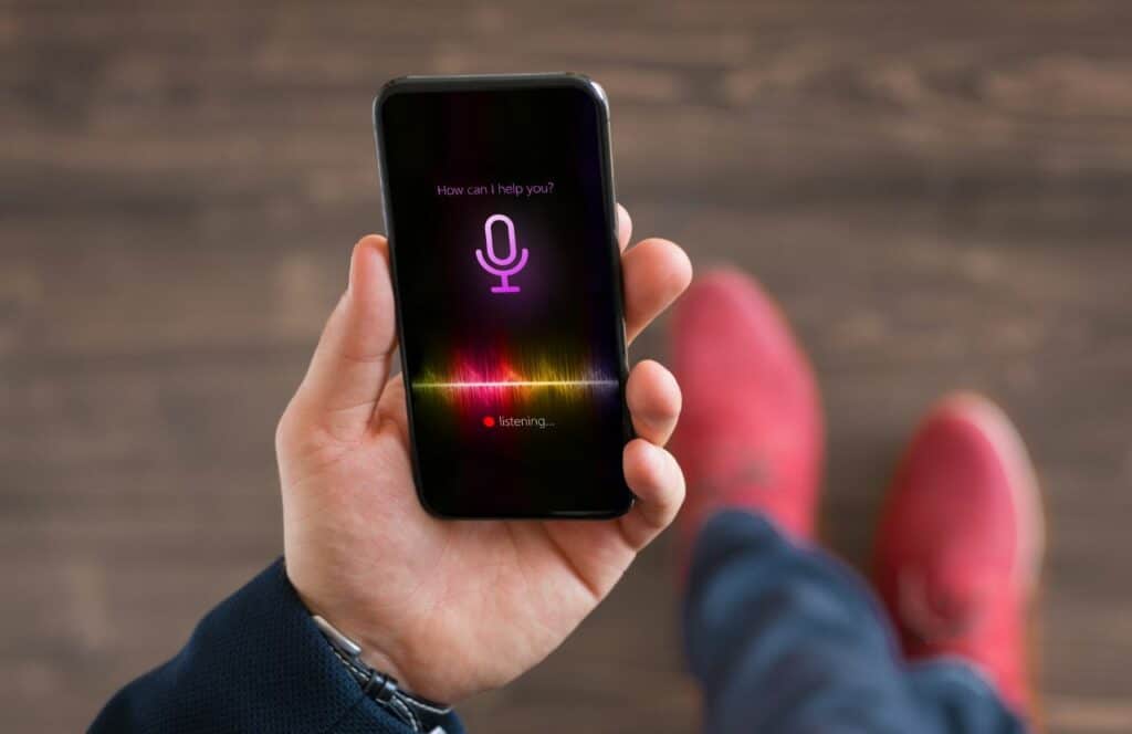 Man using a voice recorder on his phone to capture thoughts for writing blog posts . Keep reading to know how to write blog posts faster.