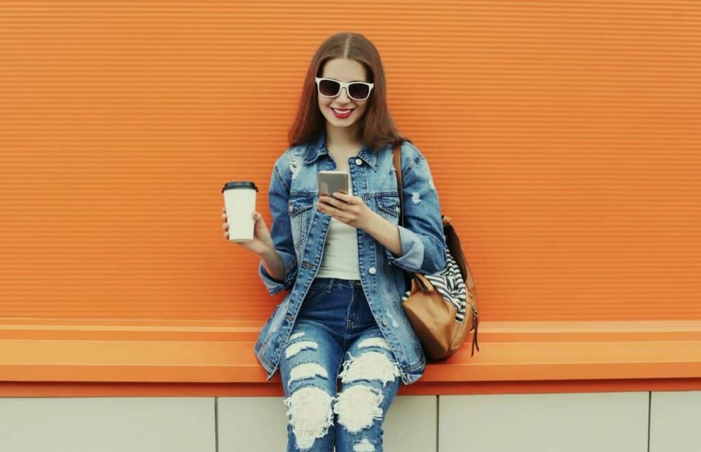 Blogger Influencer scrolling social media on her phone working on her blog post workflow.