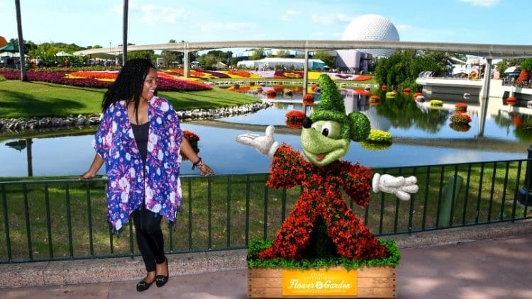 NikkyJ of ThemeParkHipster at Epcot standing next to Mickey Mouse. Keep reading to learn how this theme park blogger and Disney blogger makes money.