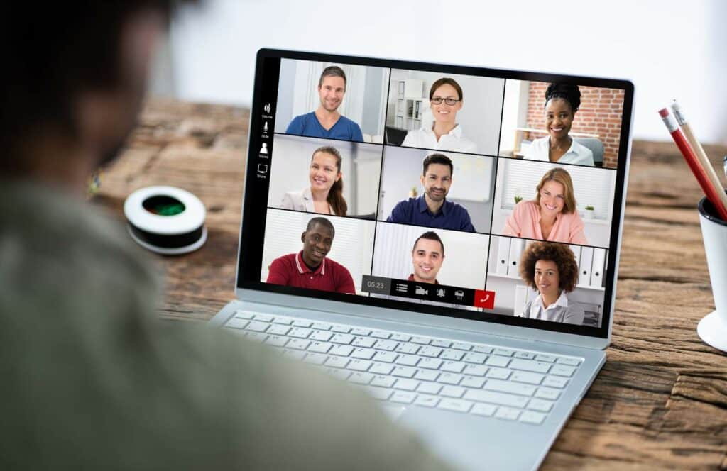 A man sitting at a table with his laptop logged onto a monthly virtual membership meetup. Keep reading to learn how to monetize your blog from day one.