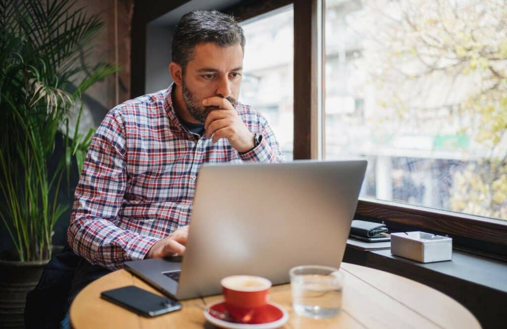 A man sitting at his desk creating his email marketing campaign for his blog. Keep reading to learn how to monetize your blog from day one.