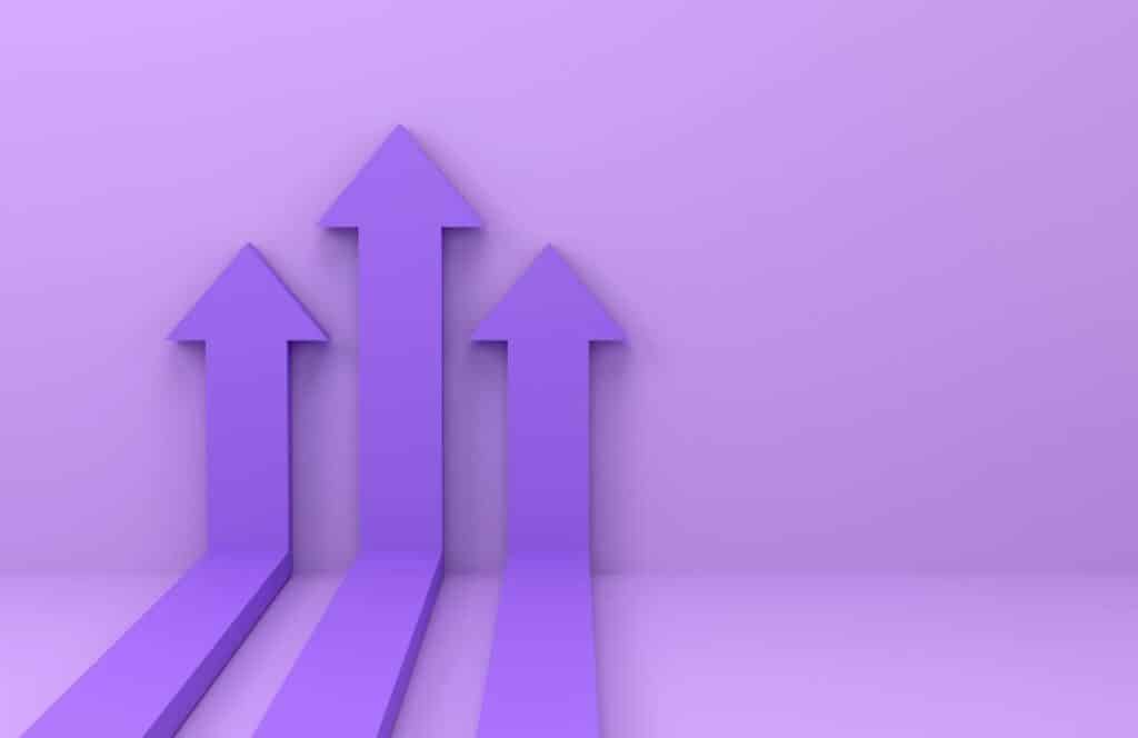 Three dark purple arrow pointing up with a light purple background wall and floor. Learn more about conversion rate optimization for your blog.