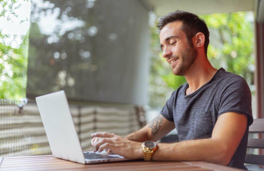 A man sitting outside on a patio while working on his blog linking strategy. Want to learn more about how to write a case study? Click here!