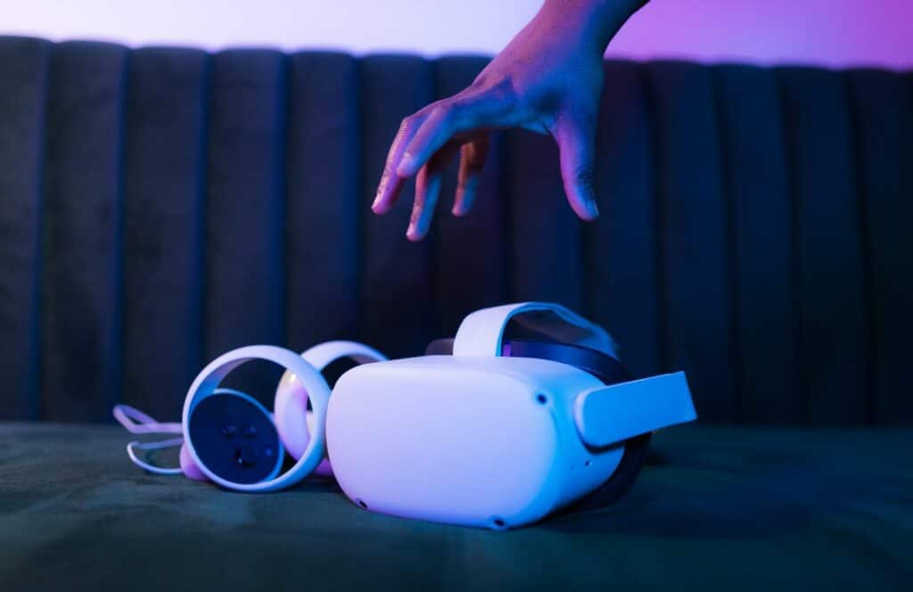 Personal grabbing an AR/VR occulus off of the sofa in a room with purple lighting. Learn more about how our lives shift to the digital world, content will only grow in importance because content is king.  